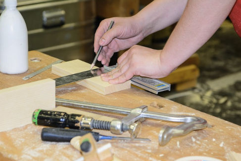 Hands measuring wood with precision tools—choosing email marketing software carefully